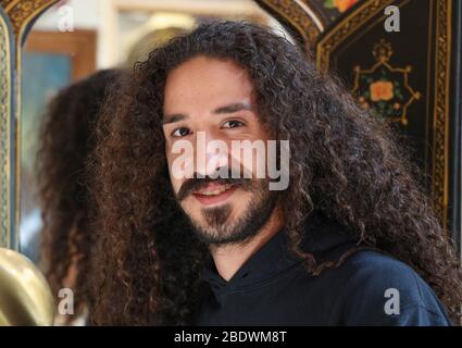 Ritratto di un giovane uomo con capelli lunghi e ricci scuri a Isfahan, Iran, Persia, Medio Oriente Foto Stock