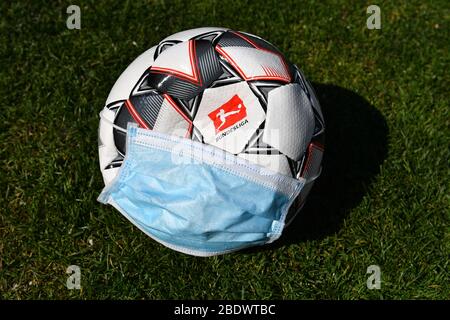 Tema foto: Seguire la corona pandemic su sport professionali e le leghe di calcio. E 'completamente aperto come si può camminare con il calcio e quando e se può essere giocato di nuovo a tutti. Ora il pnat DFL una continuazione delle operazioni di gioco dal 9 maggio 2020. Logo della Bundesliga sulla palla ufficiale Derbystar. La palla indossa una maschera protettiva, una maschera facciale, una maschera facciale. Calcio 1. Bundesliga. | utilizzo in tutto il mondo Foto Stock