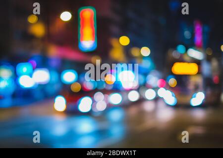 Luci bokeh del traffico cittadino di notte, immagine sfocata delle automobili sulla strada - Foto Stock