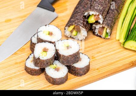 Sushi roll giapponese cibo makis su bordo di bambù accanto al coltello Foto Stock