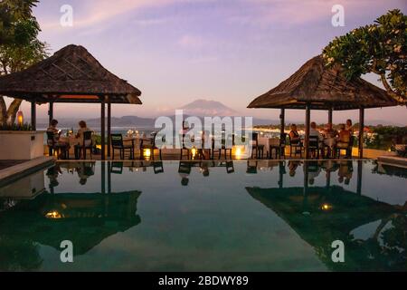 Vista orizzontale di un ristorante terrazza che si affaccia sul Monte Agung al tramonto sull'Isola di Lembongan, Indonesia. Foto Stock