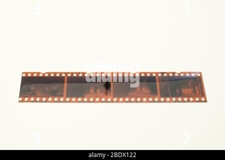 Una striscia negativa analogica a 4 fotogrammi viene fotografata sopra uno sfondo bianco. Foto Stock