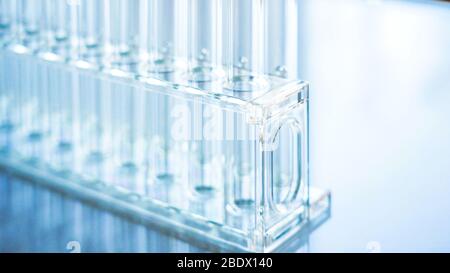 Provette vuote sui rack all'interno del laboratorio presenti sulla parte superiore del tavolo bianco Foto Stock