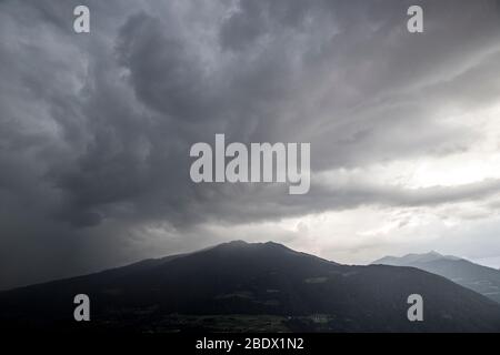 Una vista sulle colline che si affacciano sulla città di Bressanone, nella regione dell'Alto Adige, in un periodo di tempesta. Foto Stock