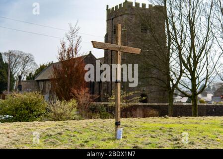 Preston, Lancashire, Regno Unito. 10 aprile 2020. Una croce di legno sul verde del villaggio a Chipping, Preston, Lancashire, che gli abitanti sono invitati a visitare durante il loro esercizio quotidiano ora che tutte le chiese sono ormai vicine sia per il culto privato e servizi pubblici durante la pandemia di Coronavirus. Credit: John Eveson/Alamy Live News Foto Stock