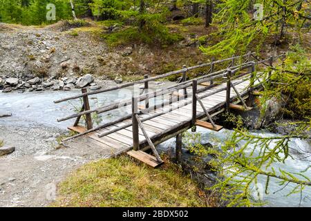 Ponte piede in legno sul torrente. Foto Stock