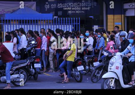 Nessuna distanza sociale, caos come cambogiano operai di fabbrica di abbigliamento in linea in su ad una banca il 1 ° giorno Phnom Penh spegne tutte le strade dentro e fuori della città prima di Capodanno cambogiano durante la pandemia di coronavirus. Phnom Penh, Cambogia. 10 aprile 2020. © Kraig Lieb Foto Stock