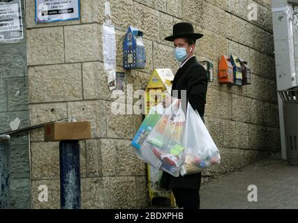 Gerusalemme. 10 aprile 2020. Una maschera di Ebreo ultra-ortodossa è vista a Gerusalemme in mezzo alla pandemia di coronavirus il 10 aprile 2020. Il numero di casi COVID-19 in Israele è salito a 10,095, ha detto venerdì il Ministero della Sanità israeliano. Il numero di morti di COVID-19 ha raggiunto 93 in Israele, ha detto il ministero. Credit: Gil Cohen Magen/Xinhua/Alamy Live News Foto Stock