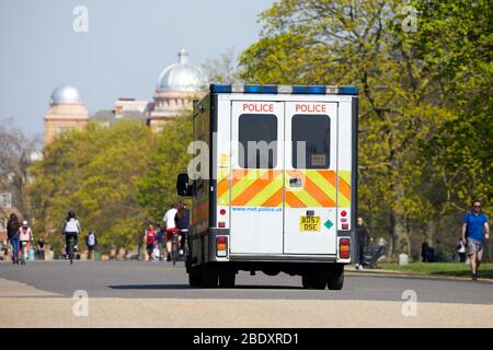 Londra, Regno Unito - 10 Apr 2020: Un pulmino di polizia pattuglia Kensington Gardens come persone prendere il loro esercizio consentito durante il blocco del coronavirus. Foto Stock