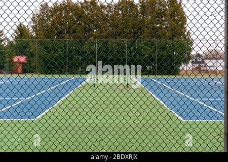 Catena di collegamento recinzione intorno a un campo da tennis Foto Stock