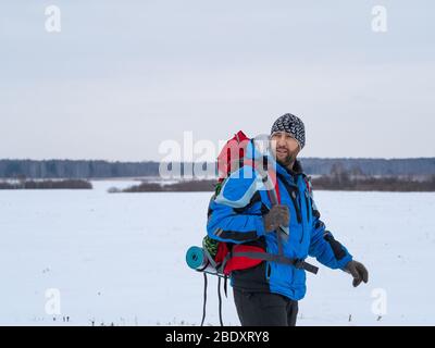 Primo piano ritratto invernale di un escursionista maschile con zaino. Concetto di avventura e stile di vita attivo. Foto Stock