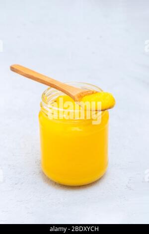 Ghee desi puro in un vaso con cucchiaio di legno, spazio per copia Foto Stock