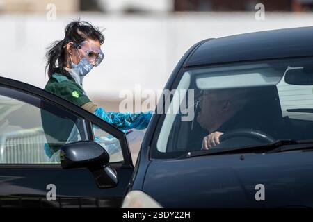 Un uomo viene inghiottito per un test di coronavirus a un drive attraverso la stazione di test presso lo stadio Ashton Gate a Bristol, Regno Unito Foto Stock