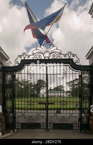 5 giugno 2019-Baguio City Filippine : enorme cancello dipinto di nero con due bandiere che sventolano sulla parte superiore del cancello. Perimetro della casa padronale a Baguio Foto Stock
