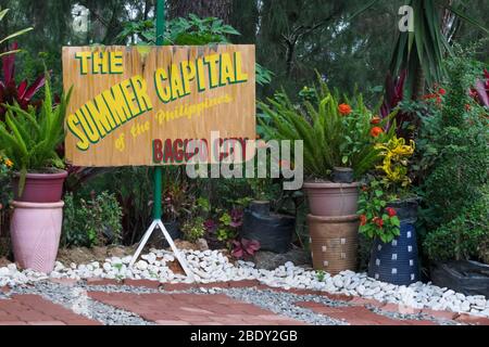 5 giugno 2019-Baguio City Filippine : un basamento di legno con testo che legge 'la capitale estiva delle Filippine, Baguio City'. Piante vibranti arun Foto Stock