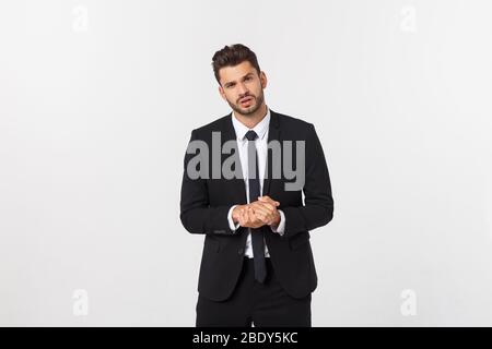 Ben vestito uomo in studio enfatizzare pensiero ponderato, pensare con attenzione e cercare di scegliere di tenere le mani e stare contro lo sfondo bianco. Foto Stock