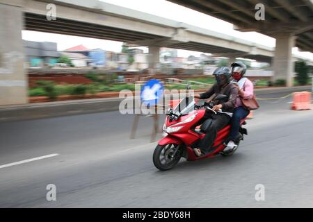 Giacarta, Indonesia. 10 aprile 2020. I motociclisti privati possono ancora viaggiare insieme ai passeggeri, sia il conducente che il passeggero devono indossare maschere e guanti, durante l'attuazione delle restrizioni sociali su larga scala (PSBB) nella regione della capitale speciale di Giacarta. Mentre il trasporto a due ruote basato su applicazione è limitato all'uso consentito solo per il trasporto di merci. (Foto di Kuncoro Widyo Rumpoko/Pacific Press) Credit: Pacific Press Agency/Alamy Live News Foto Stock