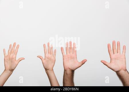 Immagine di primo piano delle mani sollevate di un uomo e di una donna isolata su sfondo bianco della parete. Foto Stock