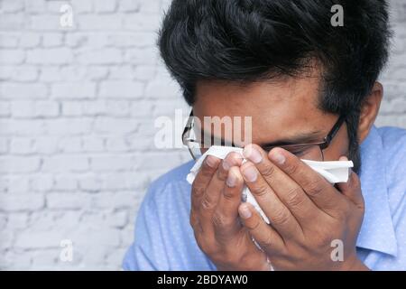 giovane uomo che si sente malessere e tossisce come sintomo di freddo Foto Stock