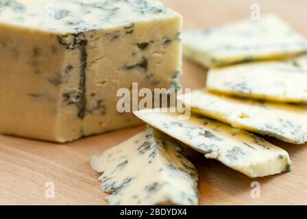 Gustose fette di formaggio ammuffito sul piatto di legno Foto Stock