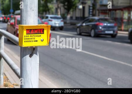 Segnale di attesa pedoni, utilizzato per aiutare le persone a attraversare la strada in modo sicuro. Testo in russo: ATTENDERE. Per attraversare la strada - premere il pulsante Foto Stock