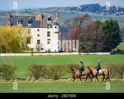 Donne a cavallo passato Scots stile baronale fortificato Ballencrieff House, East Lothian, Scozia, Regno Unito Foto Stock