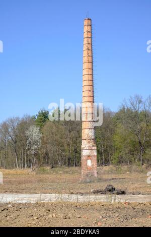 alto camino industriale si trova solo nel centro di un vuoto deserto solitario residuo della precedente fabbrica zala contea ungheria Foto Stock