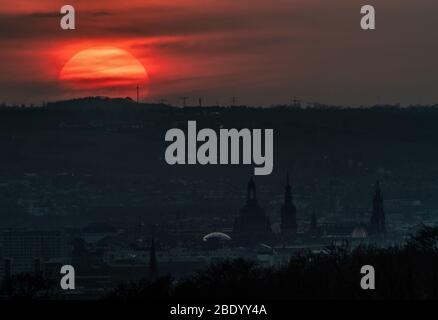 Dresda, Germania. 10 aprile 2020. Il sole tramonta di sera all'orizzonte dietro la città vecchia con la Frauenkirche (l-r), l'Hausmannsturm e l'Hofkirche. Credit: Robert Michael/dpa-Zentralbild/dpa/Alamy Live News Foto Stock