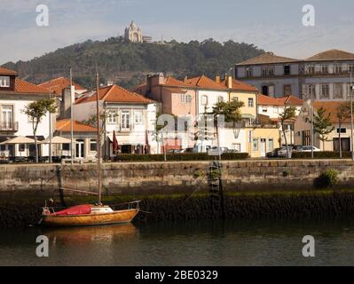 Vista con yacht in legno sul lungomare di Rio Lima e case a Viana do Castelo con il Santuario di Santa Luzia alto sopra la città del Portogallo settentrionale Foto Stock