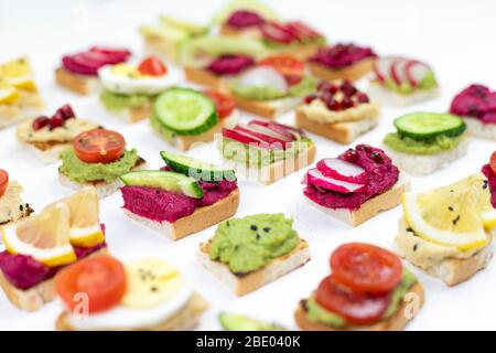 set diversi bruschette panini con hummus di barbabietole, guacamole, verdure diverse. concetto di helifood vegetariano, snack estivo. cibo patern su whit Foto Stock