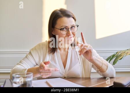 Donna matura business guardare webcam che dà video conferenza. Venditore femminile che parla con il cliente, insegnante insegnamento in remoto online, medico psicologa Foto Stock