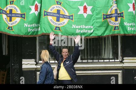 I sostenitori dell'Irlanda del Nord si rallegrano mentre camminano oltre il Rex Bar sulla Shankill Road di Belfast, dopo la vittoria dell'Irlanda del Nord contro Inghilterra, Belfast, Irlanda del Nord, 8 settembre 2005. Foto/Paul McErlane Foto Stock