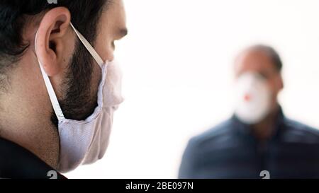 Uomo infettato anziano in maschera medica protettiva isolato in quarantena domestica. Concetto di consiglio per anziani coronavirus. Uomini anziani di sicurezza. Trasmissione di virus Foto Stock