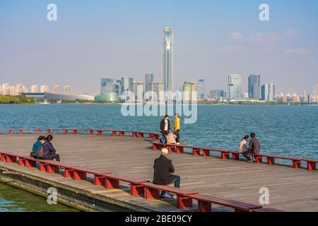 SUZHOU, CINA - NOVEMBRE 05: Vista di un molo con i turisti sul Lago Jinji con edifici cittadini in lontananza il 05 Novembre 2019 a Suzhou Foto Stock