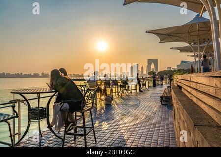 SUZHOU, CINA - NOVEMBRE 05: Vista delle persone sedute al tramonto al Moon Harbour, un popolare punto di vista sul Lago Jinji il 05 Novembre 2019 a Suzhou Foto Stock