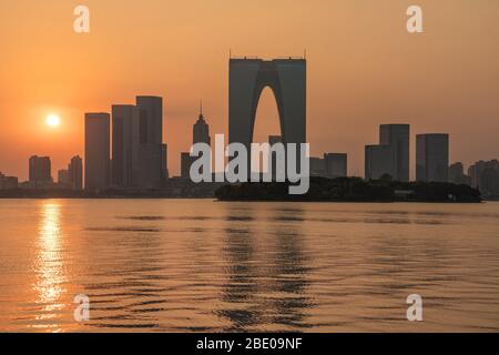 SUZHOU, CINA - NOVEMBRE 05: Veduta dello skyline della città del quartiere finanziario dal Lago Jinji durante il tramonto il 05 Novembre 2019 a Suzhou Foto Stock