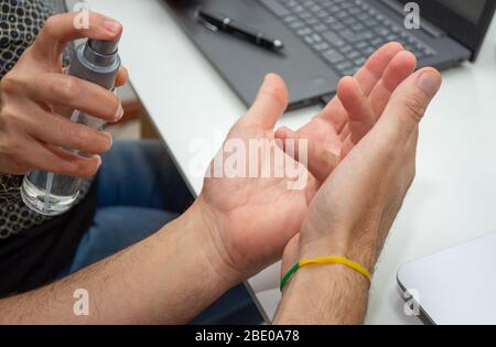 Donna al lavoro mette l'alcol nelle mani del suo partner Foto Stock