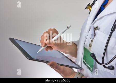 Operatore sanitario che usa la compressa per condurre la sanità. Medico o infermiere medico che scrive la prescrizione. Assistente medico che indossa lo stetoscopio Foto Stock