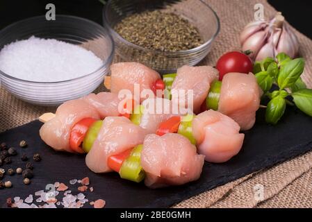 Kebab di pollo con pomodori e spezie su un piatto nero. Foto Stock