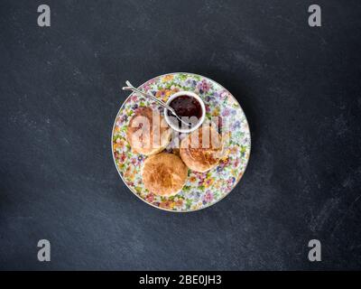 Focaccine fatte in casa appena sfornate con marmellata, sfondo di ardesia, vista dall'alto Foto Stock