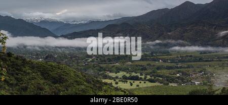 Fertile valle dell'agricoltura di Ojai, California dà modo di lontano neve coperto montagne di Lockwood Valley e basse nubi. Foto Stock
