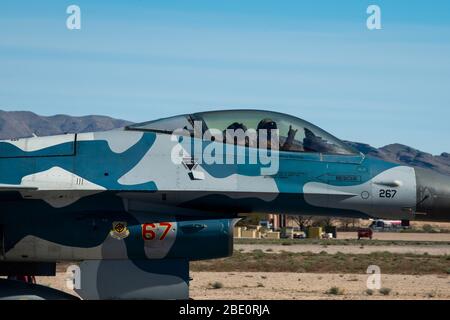 Un pilota di caccia Falcon F-16 assegnato al 64esimo Aggressor Squadron (AGRS) lancia un cartello morale prima del decollo alla Nellis Air Force, Nevada, 3 aprile 2020. Il 64esimo AGRS volò blu F-16s per onorare il personale medico e i soccorritori dalla Las Vegas Valley, nonché a livello nazionale, mentre conducendo una missione di addestramento. (STATI UNITI Foto dell'Air Force di staff Sgt. Tabatha Arellano) Foto Stock