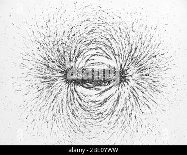 Vista finale di un campo magnetico a ferro di cavallo. Il campo si manifesta nelle linee di flusso delle limature di ferro. Le interazioni tra le limature le fanno accumulare in linee d'arco nel campo continuo. Foto Stock