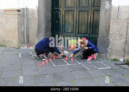 Fedeli laici, il Venerdì Santo, nel cortile della Chiesa del corpo di Cristo delle candele e del grano come segno di rinascita nel giorno di Pasqua Foto Stock