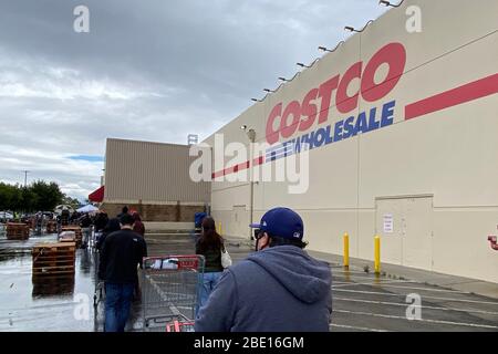 Alhambra, Stati Uniti. 10 aprile 2020. Los Angeles, Stati Uniti. Aprile 10 2020: Persone in attesa in linea con i carrelli di shopping osservando le distanze sociali per entrare Costco all'ingrosso negozio in mezzo al coronavirus globale COVID-19 pandemic, Venerdì, 10 aprile 2020, in Alhambra, California (Foto di IOS/Espa-Images) Credit: European Sports Photo Agency/Alamy Live News Foto Stock