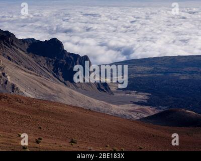 Cratere vulcanico di Haleakala con nuvole che si sgocciolano sotto Foto Stock