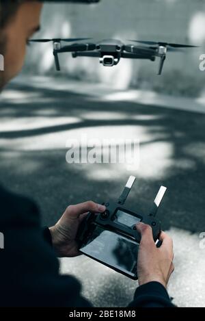 Telecomando drone. Telecomando in mano. L'uomo tiene il telecomando con le mani e controlla il drone Foto Stock