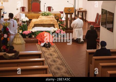 TYMOWA, POLONIA - 10 APRILE 2020. La liturgia della Passione nella Chiesa nostra Signora della Regina durante il Venerdì Santo. Sacerdote sdraiato sul pavimento. A causa del pandemi Foto Stock