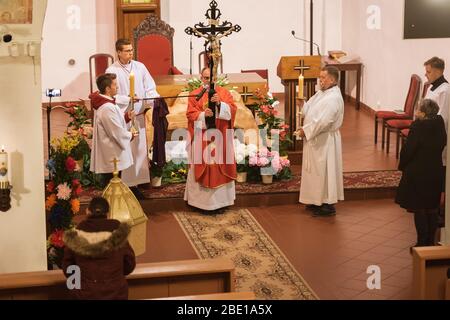 TYMOWA, POLONIA - 10 APRILE 2020. La liturgia della Passione nella Chiesa nostra Signora della Regina durante il Venerdì Santo. Sacerdote che detiene il crocifisso. Foto Stock