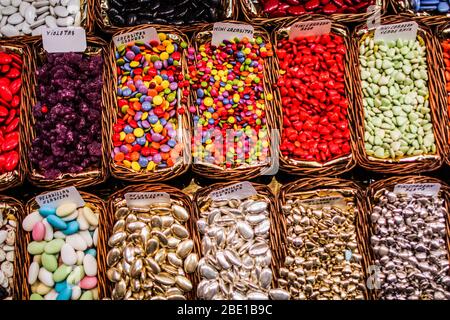 Dolci draghi di diversi colori e gusti in vassoi di vimini con etichette. Foto Stock